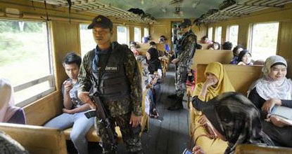 Armed officers provide security on board Train No.006 bound for Narathiwat's Sungai Kolok district in late November. 