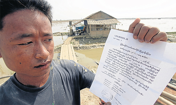 Kyew <b>Thein Swe</b> shows a letter threatening him with jail if he did not move. - 503039