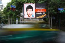 Vehicles pass by a digital billboard showing the sketch of a man suspected to be the Bangkok bomber in central Bangkok. (AFP photo)