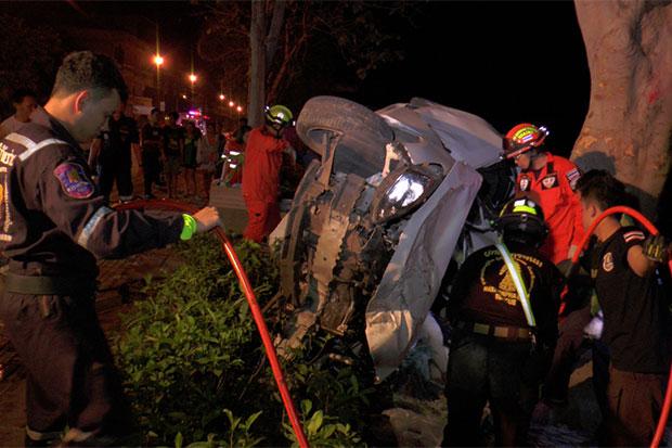 Police and rescue workers retrieve the dead and injured from a Mazda car after it crashed into a tree on Sunthornvichit Road along the Mekong River in Muang district of Nakhon Phanom early Saturday. Two people, including the driver, were killed and another one seriously hurt. (Photo by Pattanapong Sripiachai)