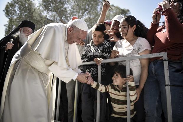 A boy shakes the hand of Pope Francis as he greets migrants and refugees at the Moria refugee camp on the Greek island of Lesbos on Saturday. (Reuters Photo)