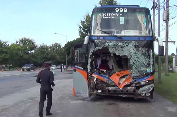 A police officer inspects the crash scene in which an elephant was killed after being hit by this inter-provincial bus in Hang Chat district, Lampang on Friday night 