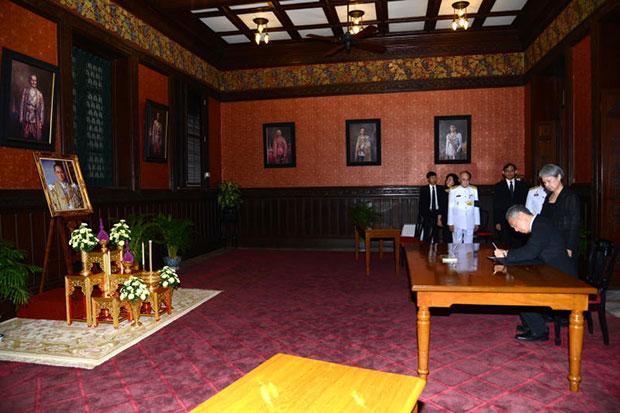 Singapore Prime Minister Lee Hsien Loong (second right) and his wife Ho Ching (right) sign a condolence book for King Bhumibol at the Red Room of the Royal Household Bureau inside the Grand Palace on Friday. (Royal Household Bureau photo)